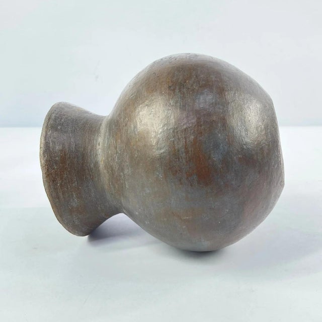 This handcrafted clay pot is a traditional vessel made by the Zulu people of South Africa. Known for their skill in...