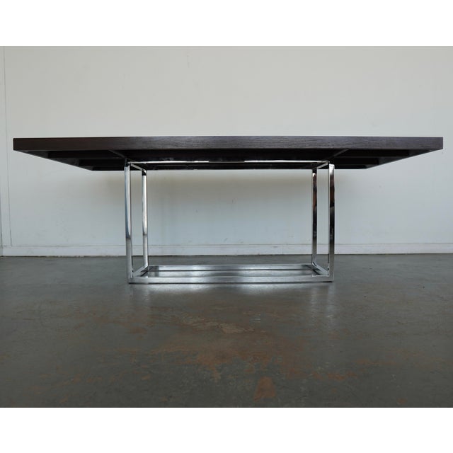 A sophisticated modern dining table by Mitchell Gold + Bob Williams, featuring a rich, dark wood top paired with a sleek...