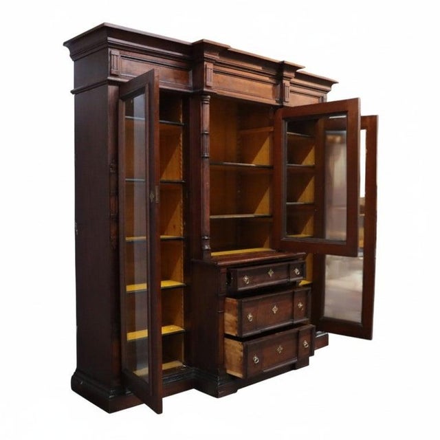 An impressive oversized Victorian secretary desk and bookcase crafted from walnut and burl wood, dating to approximately...