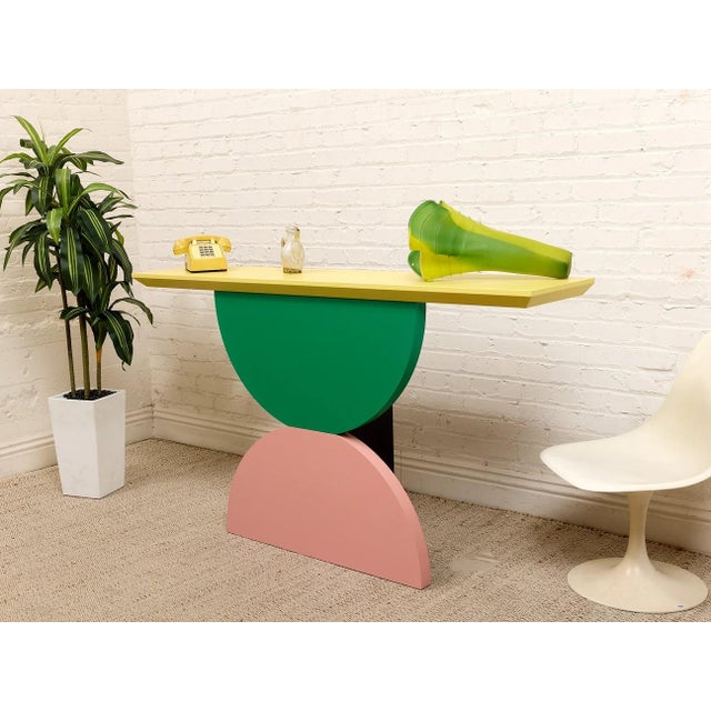 A playful postmodern console table with a bold sculptural presence and unmistakable Memphis-inspired energy. The design...