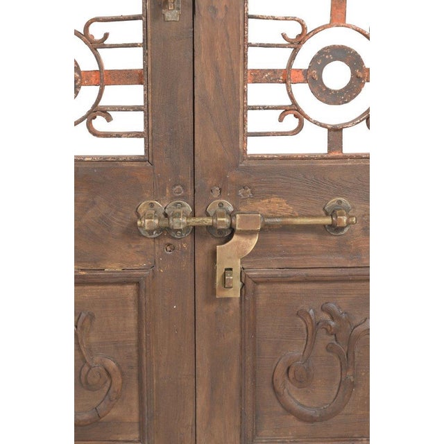 This Vintage Indian Carved Teakwood and Iron Door is a striking architectural piece that beautifully combines the warmth...