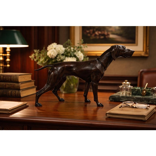 A finely modeled vintage sculpture depicting a standing hunting dog, rendered with elegant anatomical detail and a poised,...