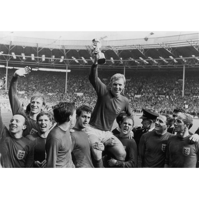 World Cup Victory England captain Bobby Moore (1941 - 1993) holds up the Jules Rimet trophy as he is carried on the...