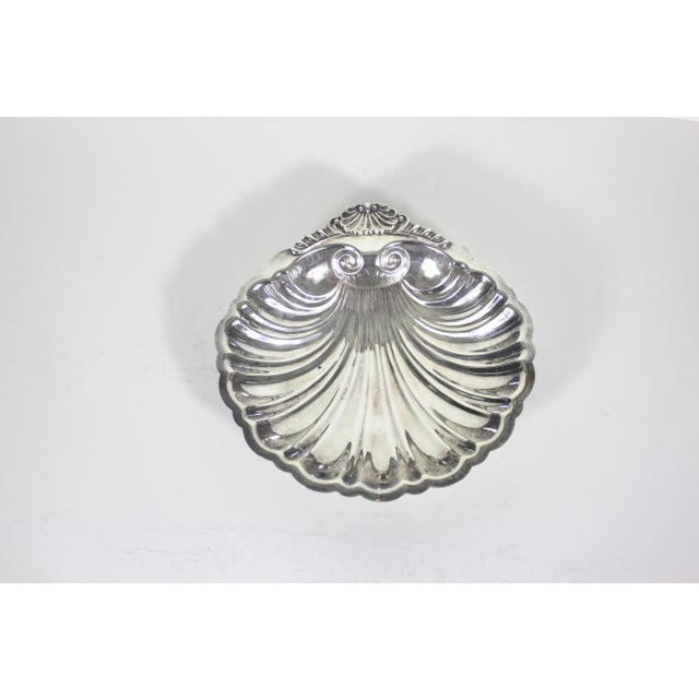 This is a vintage footed silverplated clam shell dish or bowl with feet. It has some patina, scratches and some spots of...