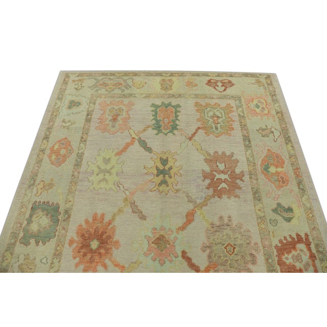 This modern Turkish Oushak rug is a stunning piece of art that has been handwoven using traditional techniques by skilled...