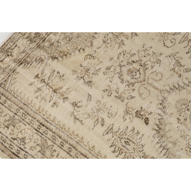 This is a vintage Turkish Oushak rug from the Mid 20th Century. The piece was hand-knotted.