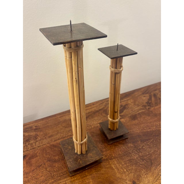 Sculptural pair of vintage candlesticks combining bundled natural bamboo, wrapped cane and heavy dark-finished steel bases...