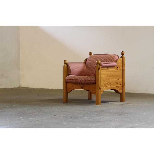 Crafted in Danish pine in the 1970s, this lounge chair stands as a quietly light hearted yet imposing piece, its patina...