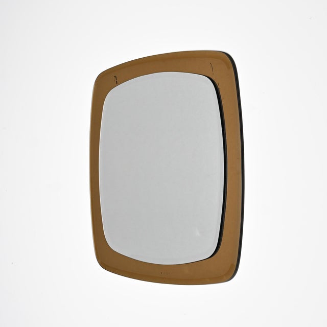 Square mirror with rounded corners, made in the 1970s. The central pane of glass is framed by a wide border of smoked...