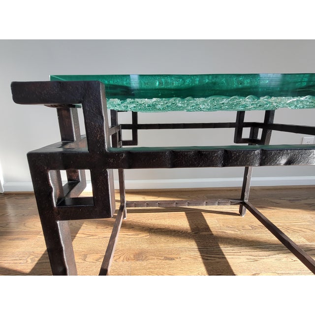 This unique end table features a stylized Asian base designed in hammered metal. Its top is molded fused glass with a soft...