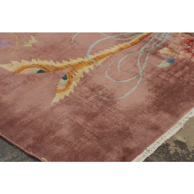 Hand-knotted in wool and originating circa 1920-1930, this 9x11 antique Chinese Peking rug is a distinguished addition to...