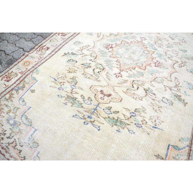 This is a vintage Turkish Oushak rug from the 1960s. The piece was hand-knotted.