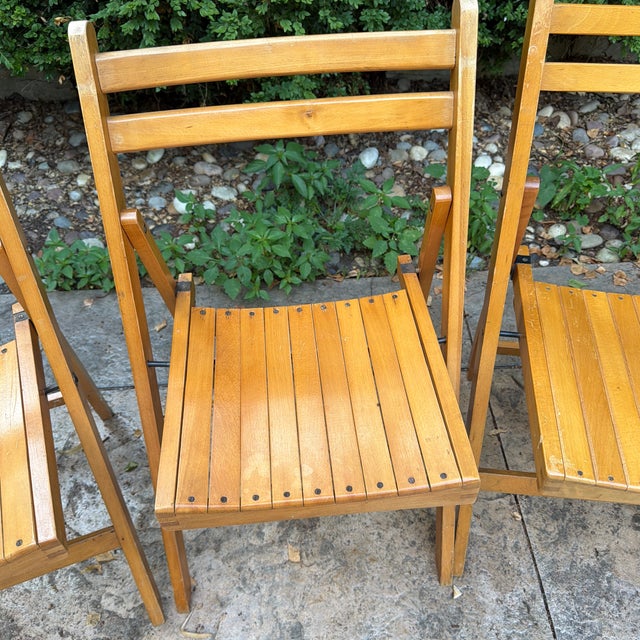 A beautiful and highly functional set of four mid-century modern folding chairs manufactured by Nevco Furniture Corp...