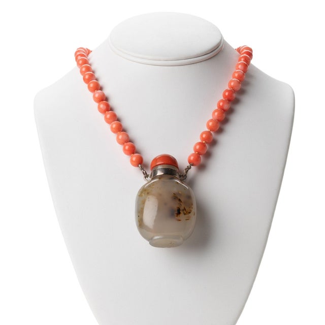 Natural coral bead necklace with a Chinese shadow agate snuff bottle pendant with coral stopper. The bottle stopper has...