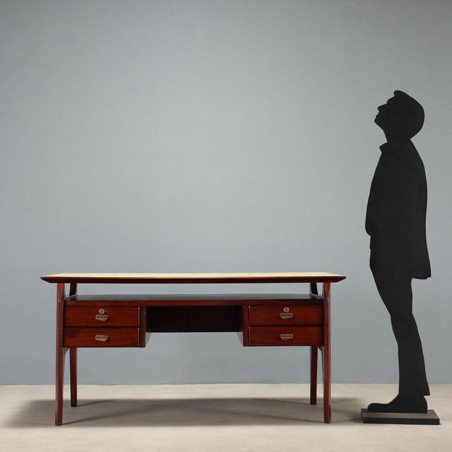 Vintage Italian-made desk with exotic wood veneer, four drawers with brass handles, and a back-treated glass top in yellow...