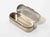 A refined sterling silver hinged box of elongated oval form, featuring softly rounded ends and a clean minimalist...