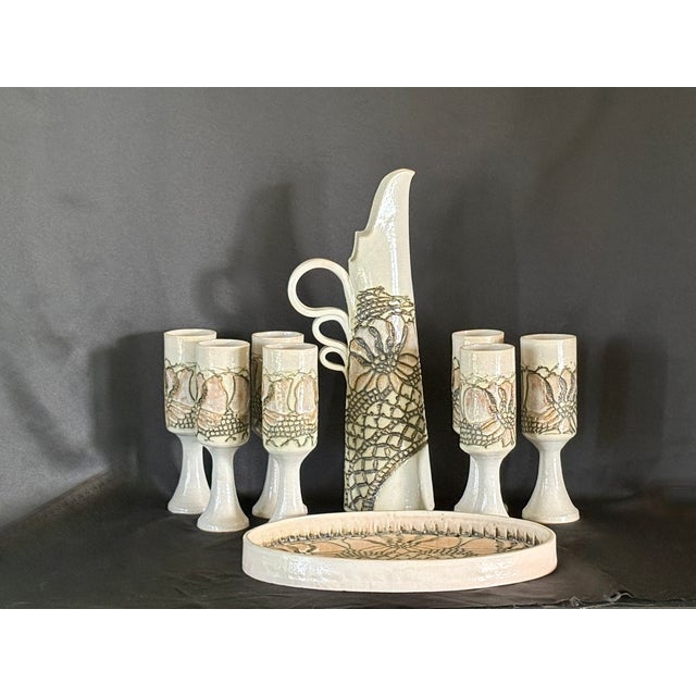 This is a beautiful set of handmade pottery. It is rare full drink set that includes a large pitcher, SEVEN stemmed cups...