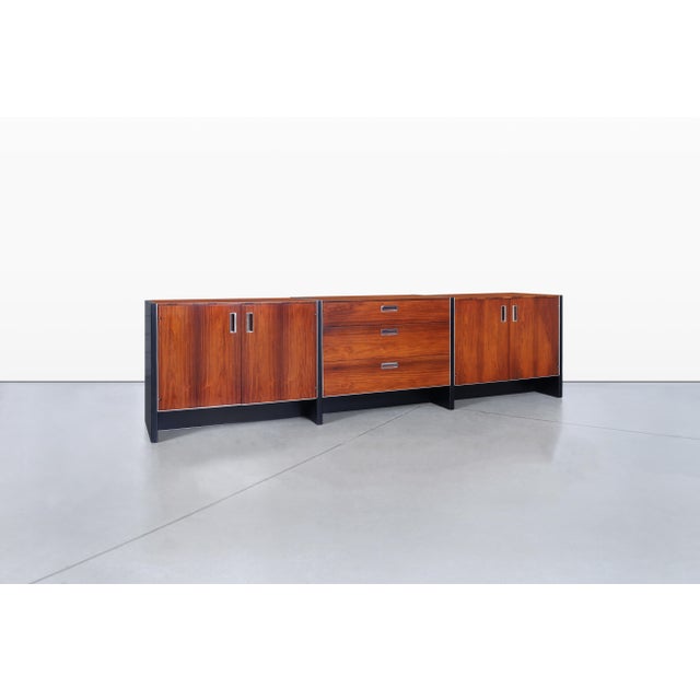 Experience the elegance of mid-century design with this stunning rosewood credenza, a masterpiece crafted by Robert Baron...
