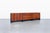 Experience the elegance of mid-century design with this stunning rosewood credenza, a masterpiece crafted by Robert Baron...
