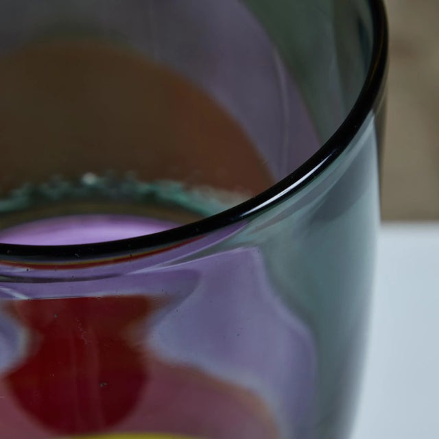 A striking hand blown glass vase in a rainbow of block colors, with drip marks at the center of the piece. Signed by the...