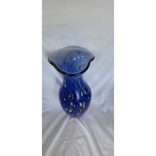 Gorgeous cobalt blue art glass valse decorated with vibrant multi-colored millefiori inclusions and elegant swirling...