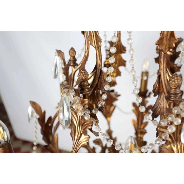 Larger metal chandelier in Florentine style with trimmings of hand-cut lead crystal. The chandelier has seven bulbs with a...