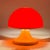 Italian Space Age mushroom table lamp produced during the 1970s. The lamp features a rounded orange diffuser resting on a...