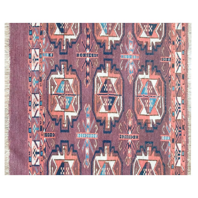 An early 20th-century Persian Yamout rug, handwoven in a distinctive tribal vocabulary, with a series of stylized floral...