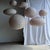 Medium-sized oval pendant light in a flattened pinkish-brown Japanese style, crafted from rattan and natural linen....