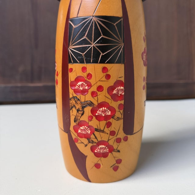 Elegant vintage sōsaku kokeshi by Sato Suigai, born in Gunma in 1920. The wooden doll has a refined form and wears a warm...