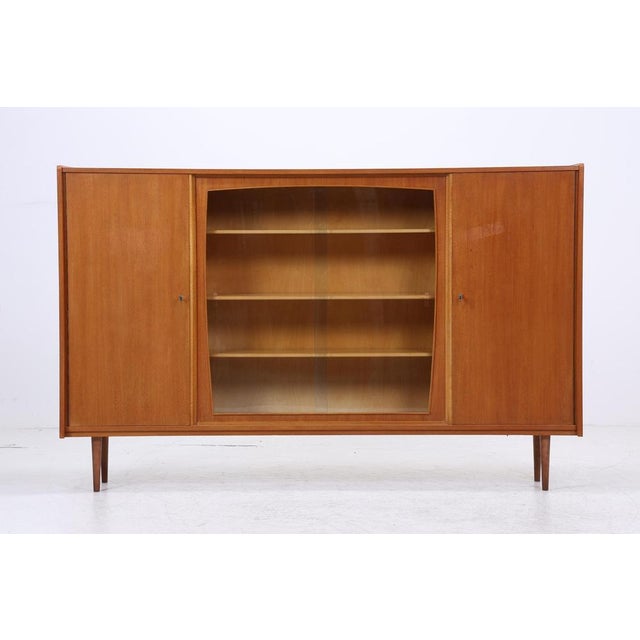 Beautiful mid-century display cabinet from the 1960s • Warm, natural wood grain finish • Central sliding glass doors for...