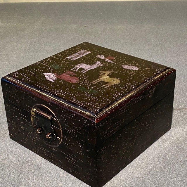 Charming square hardwood treasure box, hand-decorated with mother-of-pearl shell inlay on the lid. The artwork depicts the...