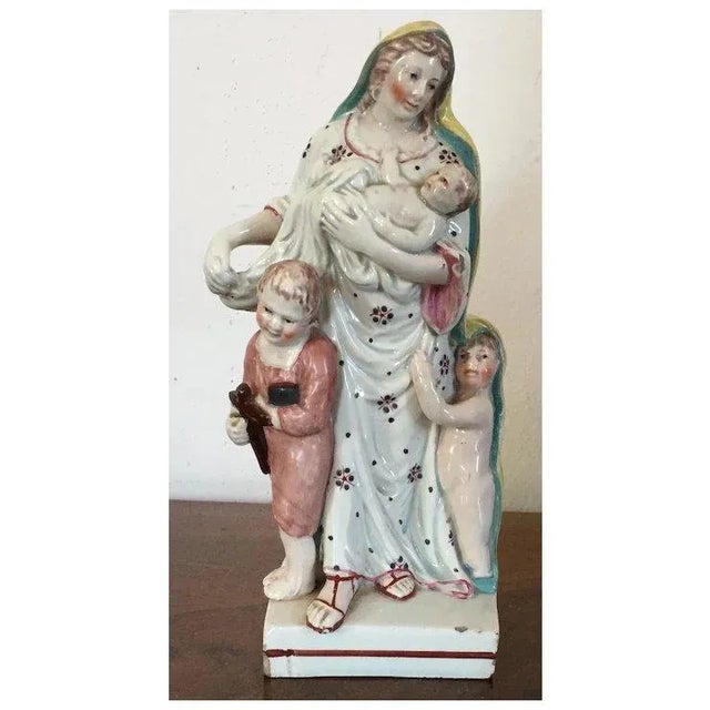 Antique early 19th c. English Staffordshire pearlware figure of Faith with a boy and a girl at her feet and a baby in her...