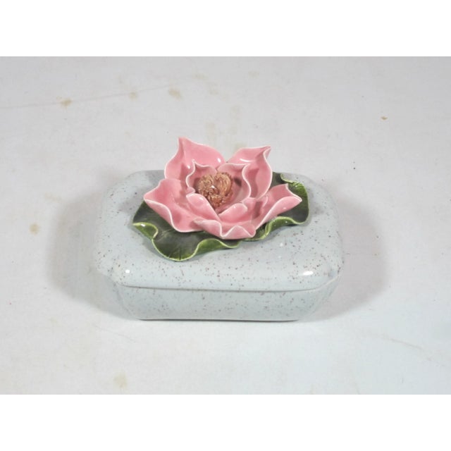 California Pottery ceramic box with applied flower on lid. The rectangular shaped box is grey with brown speckles, It has...