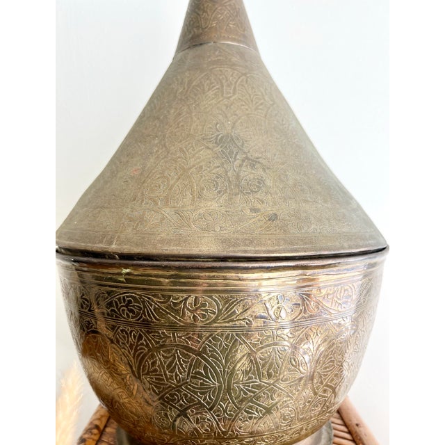 This large brass Moroccan lidded vessel, resembling a tagine, showcases authentic craftsmanship and cultural charm....