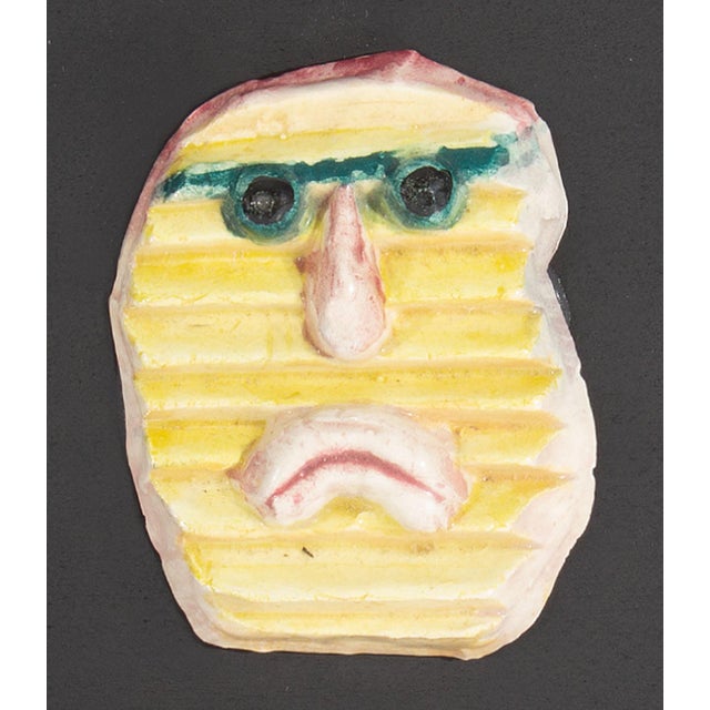 A 1970s ceramic tile by the American artist Mark Bulwinkle (born 1946). This ceramic piece depicts an abstract face made...