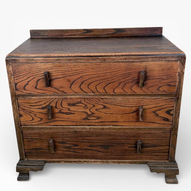 A compact and well-proportioned Art Deco oak chest of drawers, dating to the early 20th century. The piece features bold,...