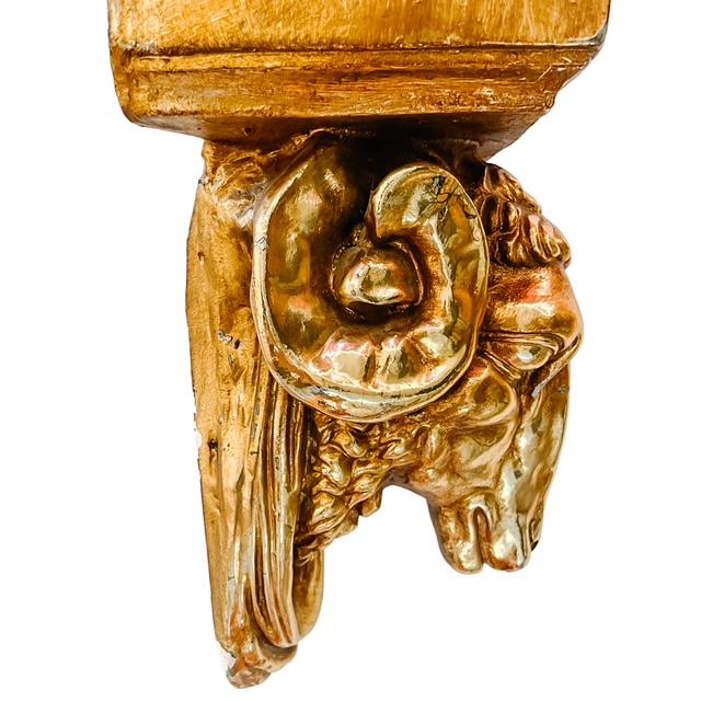 A striking Neoclassical wall statement piece featuring a dramatic sculpted ram's head below an ornate palmette-detailed...