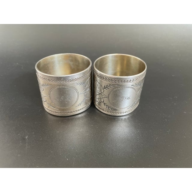 Presenting a pair of Antique Aesthetic Movement nickel silver napkin rings, features engraved floral motifs and accented...