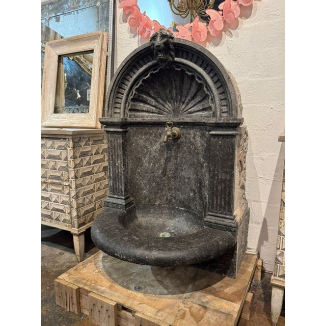 This rare 19th century Belgian black marble wall fountain is a stunning outdoor water feature that adds a touch of...