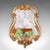 This is an antique Baroque wall mirror. A French, ornate giltwood vanity mirror, dating to the Edwardian period, circa...