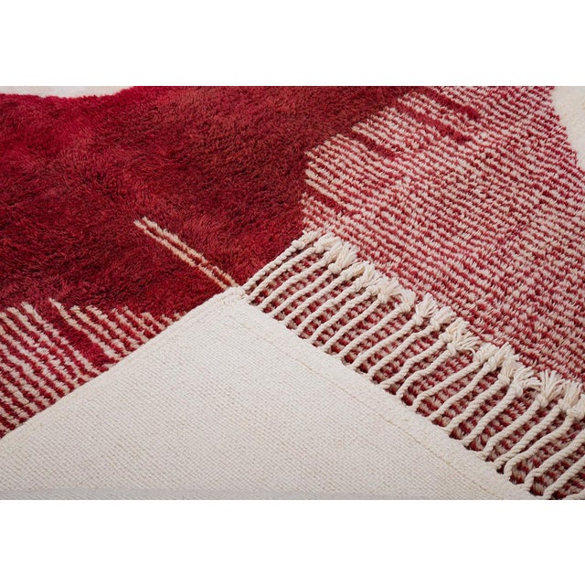 Rich Burgundy and Cream tones define this striking hand-knotted wool rug. Its bold geometric design brings symmetry and...
