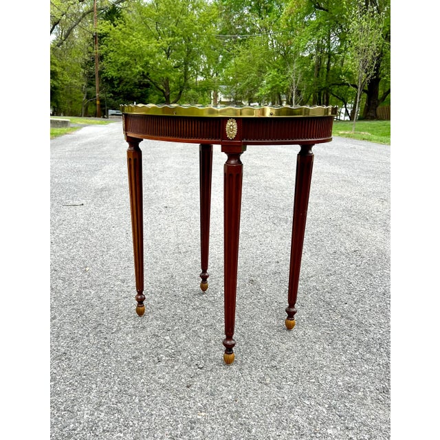 An elegant and refined oval side table by Baker Furniture, part of their Stately Homes of England and Scotland Collection,...