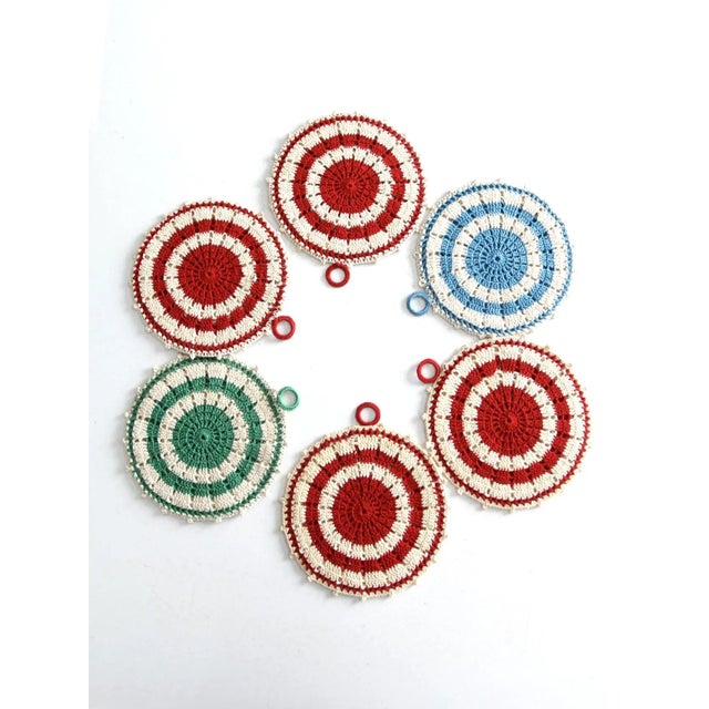 This is a set of six crotchet pot holders. The round handmade trivets feature four red stripe, 2 green stripe, and one...