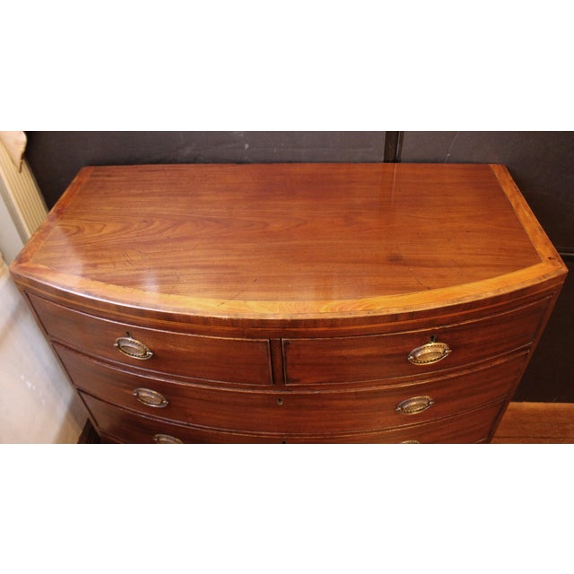 Late 18th century George III period bowfront chest of drawers, English. 2 short over 3 long drawers. Raised on French...