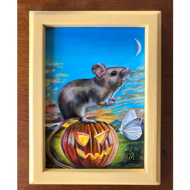 In "Harvest Dreams," a mouse perches atop a carved pumpkin, gazing into a twilight sky where a crescent moon hangs above....