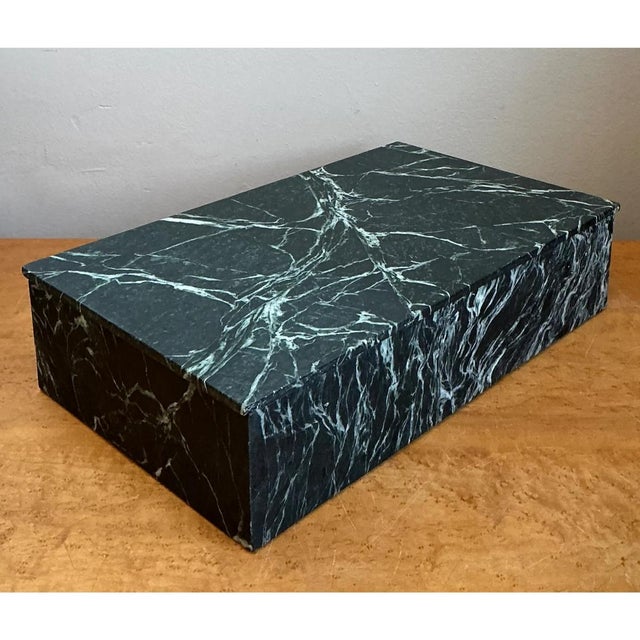 This vintage lidded box is a sleek, low-profile object finished in a dramatic faux-marble treatment that reads as deep...