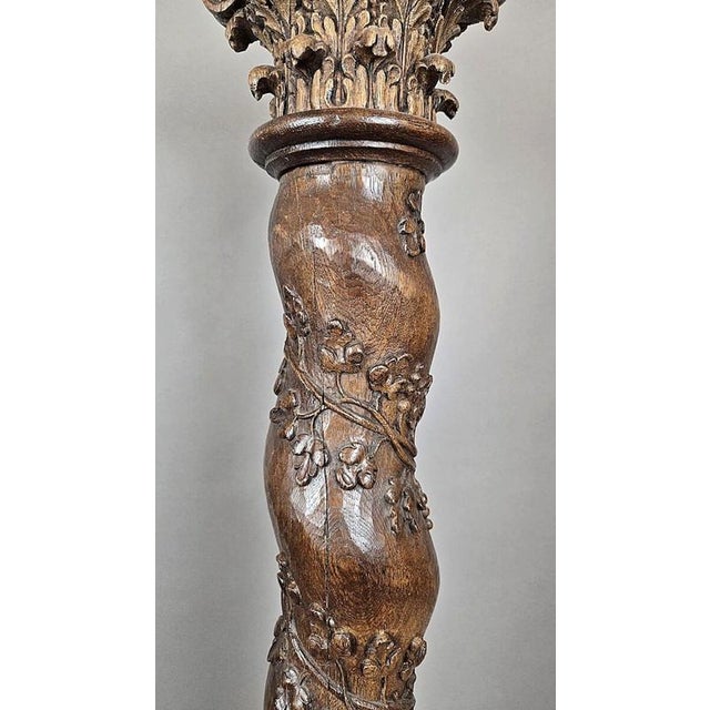 Pair of carved oak twisted columns, decorated with vine leaves, tendrils, and clusters of grapes, topped with Corinthian...