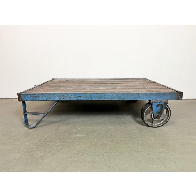 Former pallet truck from a factory now serves as a coffee table. It features a blue iron construction with two original...
