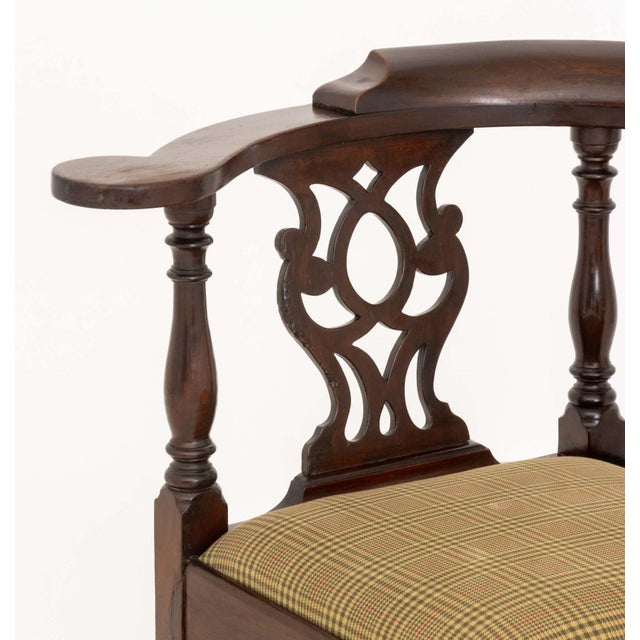 George III Mahogany Corner Chair, with openwork back splats, plaid beige upholstered drop seat on four legs conjoined by...